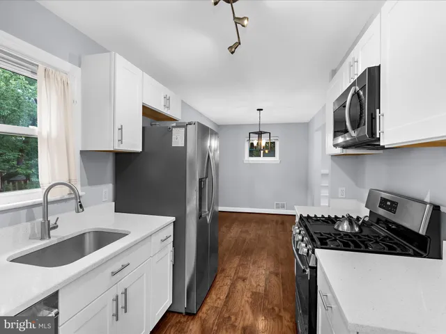 a kitchen with stainless steel appliances a sink stove and cabinets