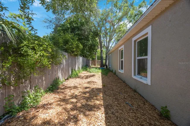 a pathway of a house with backyard and trees