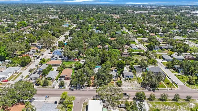 an aerial view of residential houses with outdoor space and trees
