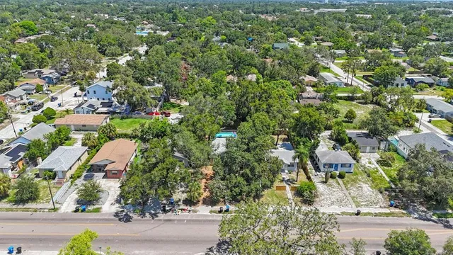 an aerial view of residential houses with outdoor space and trees