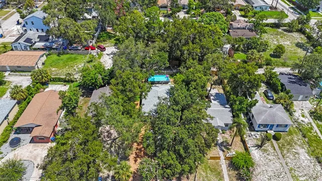 an aerial view of residential house with outdoor space and trees all around