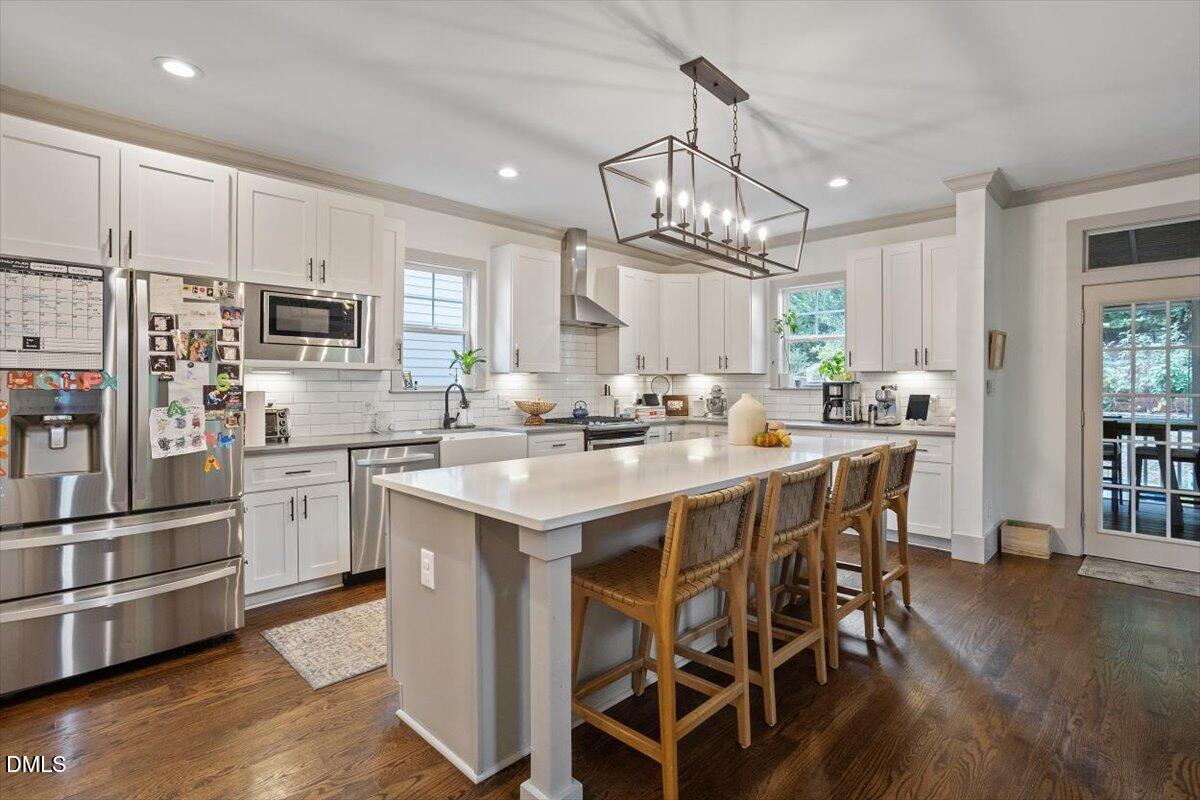 1303 Nottingham Road Raleigh, NC 27607 - Photo 7 of 33 a kitchen with stainless steel appliances kitchen island granite countertop a table chairs and a refrigerator