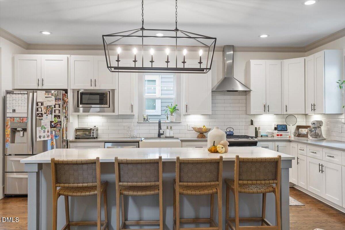 1303 Nottingham Road Raleigh, NC 27607 - Photo 9 of 33 a kitchen with stainless steel appliances granite countertop a stove top oven a refrigerator a sink and white cabinets