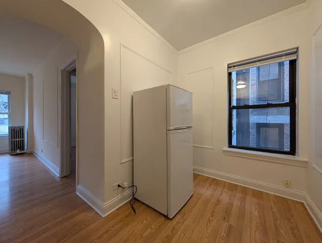 an empty room with wooden floor and a window