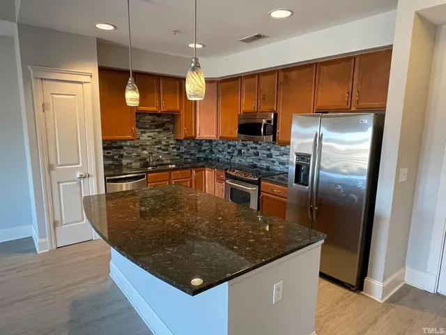 a kitchen with a counter space and wooden floor