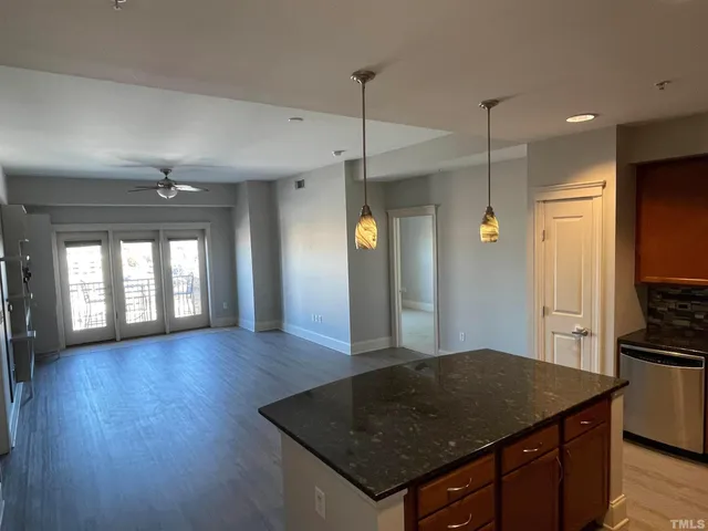 a kitchen with stainless steel appliances granite countertop a sink and wooden floor
