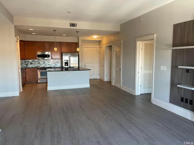 a view of a big room with wooden floor closet and windows