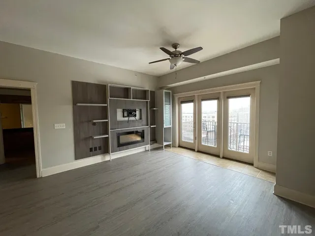 a living room with a wooden floor and a fireplace