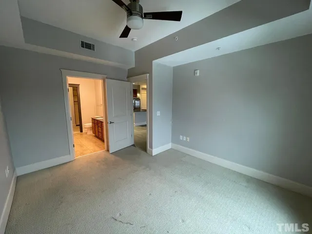 an empty room with a window and ceiling fan