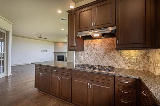 a kitchen with granite countertop a sink cabinets stainless steel appliances and a window