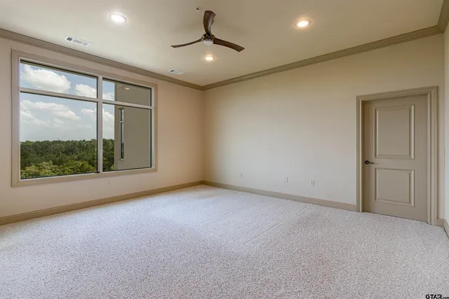en empty room with windows and ceiling fan