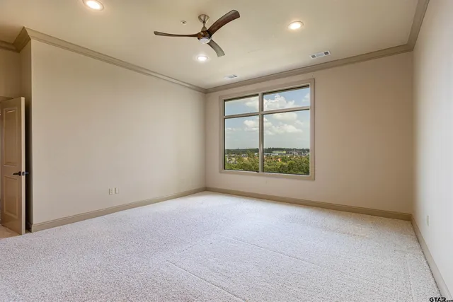 an empty room with a ceiling fan and window