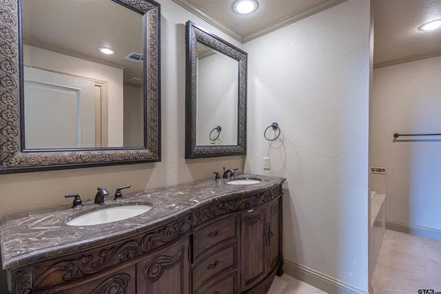 a en suite bathroom with a granite countertop sink and a mirror