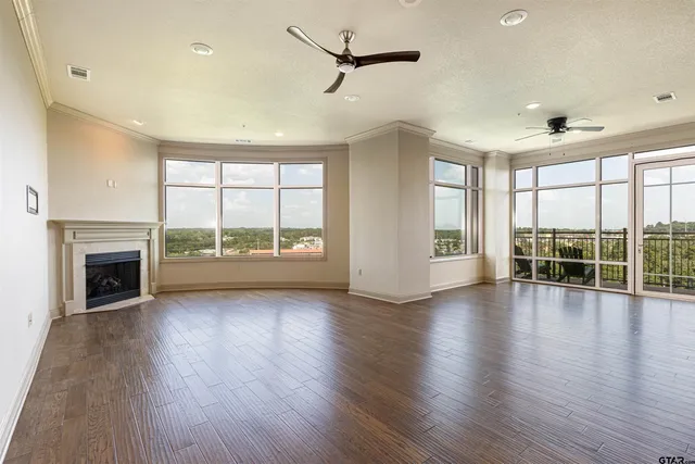 a living room with furniture large window and wooden floor