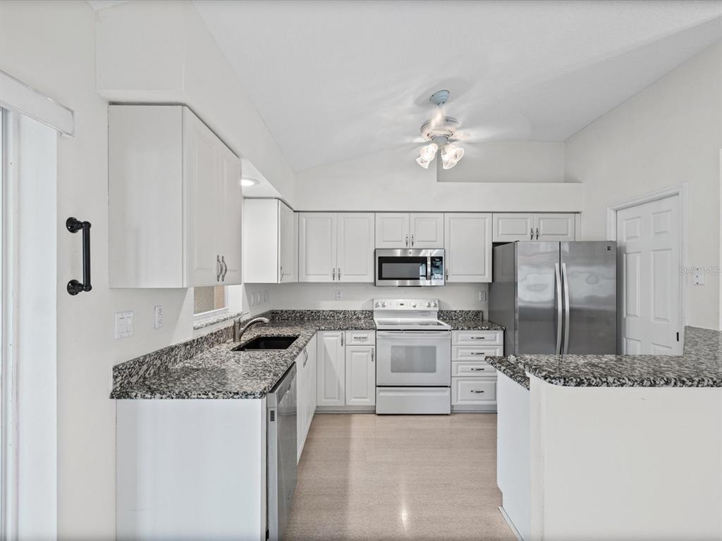 11621 Holly Ann Drive New Port Richey, FL 34654 - Photo 14 of 59 a kitchen with stainless steel appliances granite countertop a sink stove and refrigerator