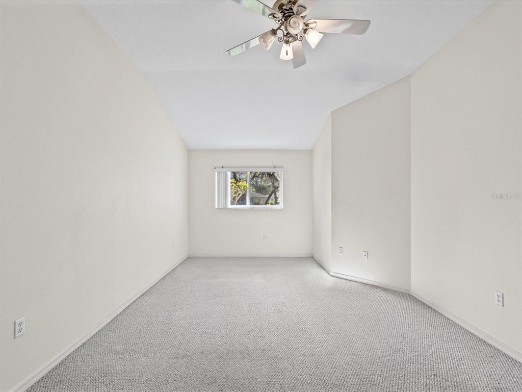 11621 Holly Ann Drive New Port Richey, FL 34654 - Photo 27 of 59 an empty room with windows and chandelier fan