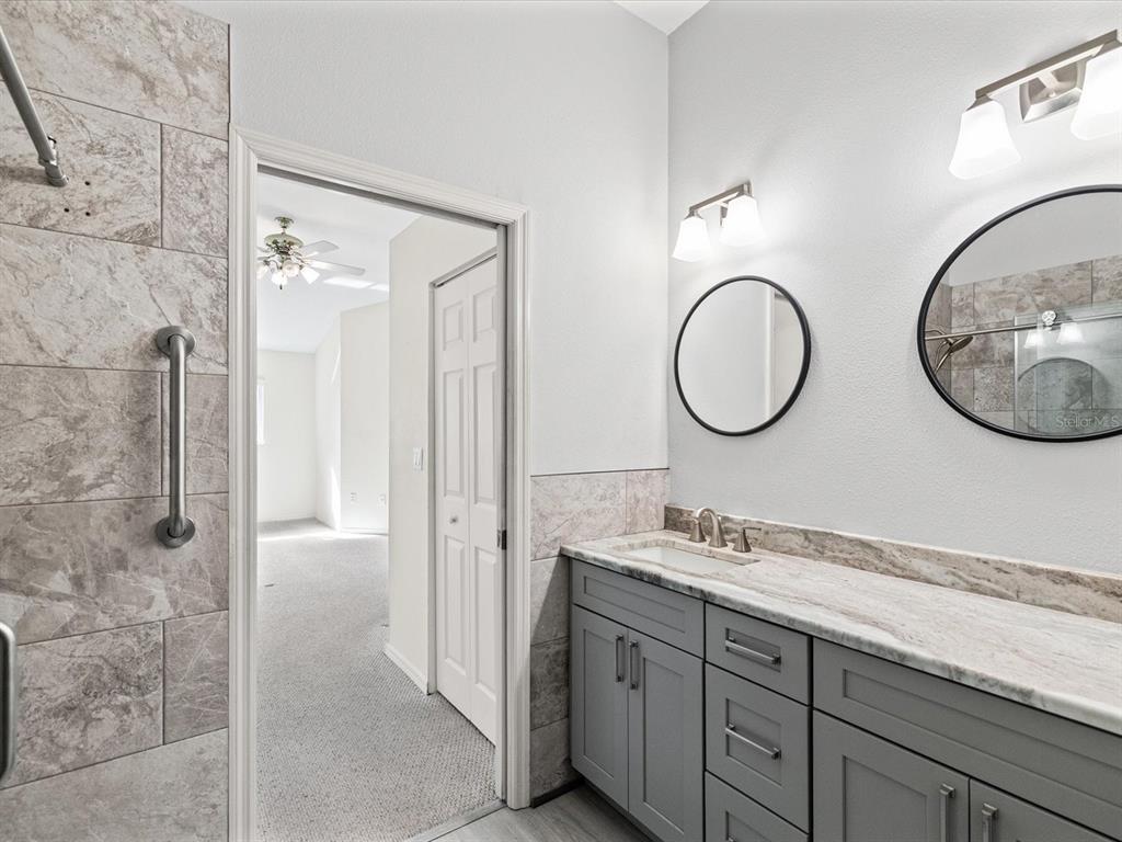 11621 Holly Ann Drive New Port Richey, FL 34654 - Photo 28 of 59 a bathroom with a double vanity sink mirror and shower