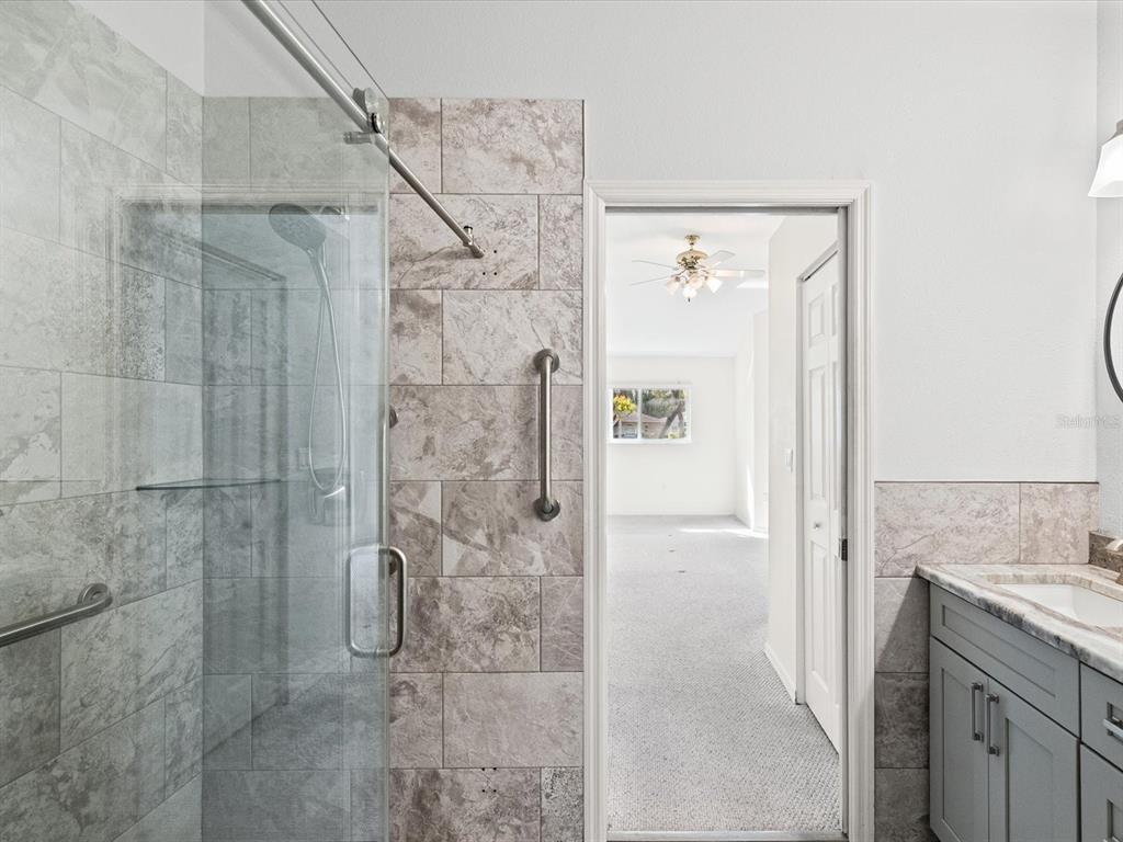 11621 Holly Ann Drive New Port Richey, FL 34654 - Photo 29 of 59 a bathroom with a granite countertop shower mirror and a sink
