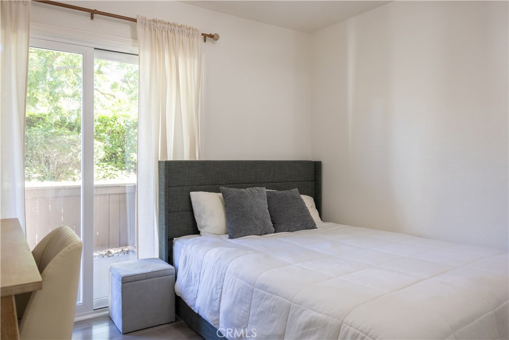 21991-143 Rimhurst Drive Lake Forest, CA 92630 - Photo 10 of 14 a bedroom with a bed and wooden floor