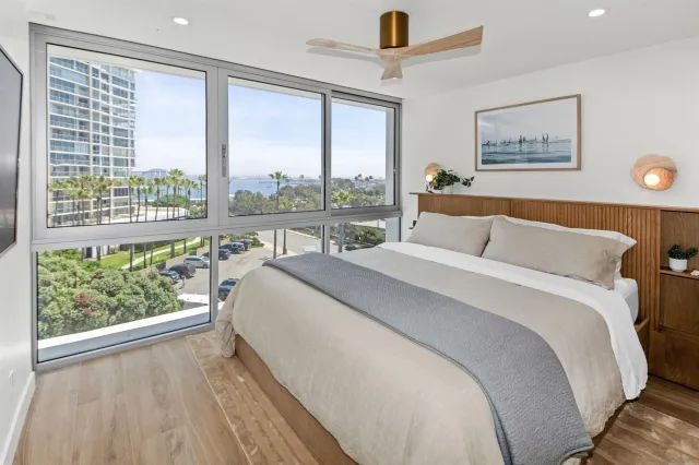 a bed sitting in a bedroom next to a large window