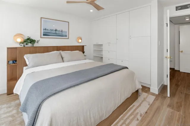 a bedroom with bed and wooden floor