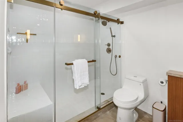 a bathroom with a shower a toilet and sink