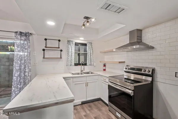 a kitchen with a stove sink and cabinets