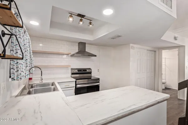 a kitchen with stainless steel appliances kitchen island a stove a sink and a refrigerator