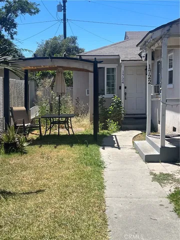 a patio with a table and chairs and potted plants