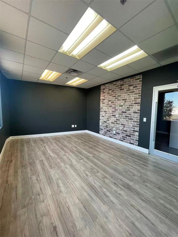 7075 Kingspointe Parkway, Unit 9 Orlando, FL 32819 - Photo 24 of 49 a view of an empty room with wooden floor and a kitchen