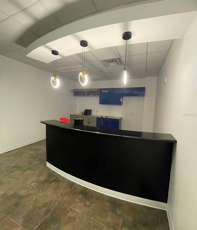 7075 Kingspointe Parkway, Unit 9 Orlando, FL 32819 - Photo 30 of 49 a kitchen with a kitchen island stainless steel appliances a refrigerator and stove