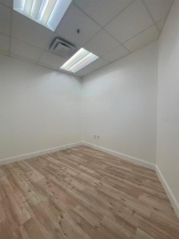 7075 Kingspointe Parkway, Unit 9 Orlando, FL 32819 - Photo 33 of 49 an empty room with wooden floor and fan
