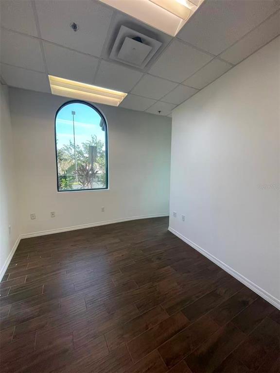 7075 Kingspointe Parkway, Unit 9 Orlando, FL 32819 - Photo 34 of 49 an empty room with wooden floor and windows