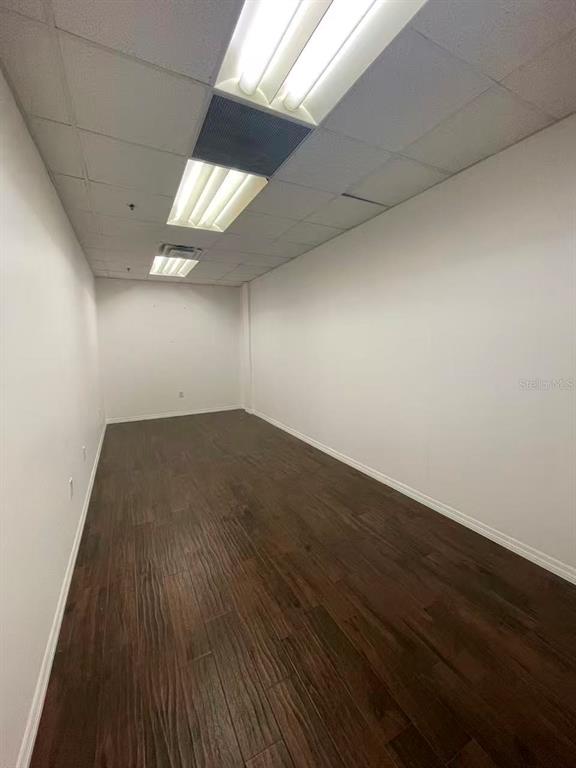 7075 Kingspointe Parkway, Unit 9 Orlando, FL 32819 - Photo 36 of 49 an empty room with wooden floor and windows