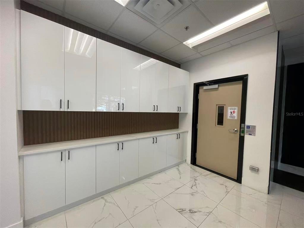 7075 Kingspointe Parkway, Unit 9 Orlando, FL 32819 - Photo 4 of 49 a kitchen with granite countertop white cabinets and white appliances