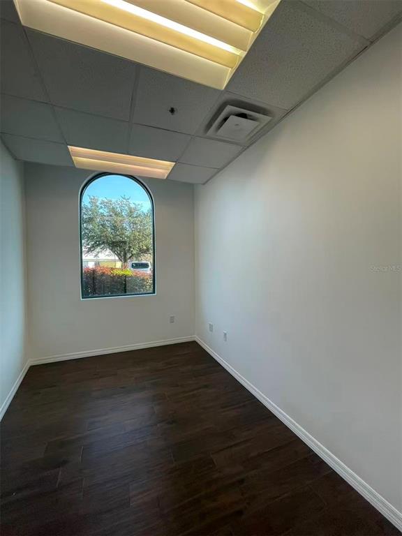 7075 Kingspointe Parkway, Unit 9 Orlando, FL 32819 - Photo 43 of 49 an empty room with wooden floor and windows