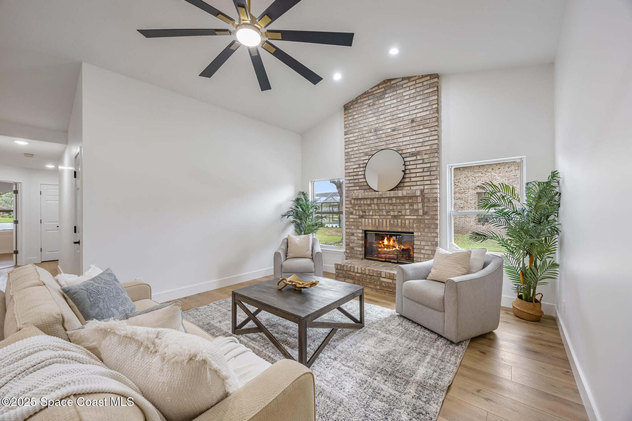 4737 Canard Road Melbourne, FL 32934 - Photo 19 of 35 a living room with furniture a fireplace and a chandelier