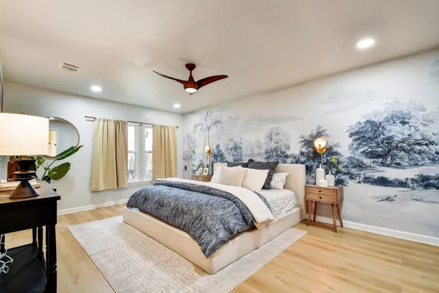 a spacious bedroom with a large bed and a chandelier