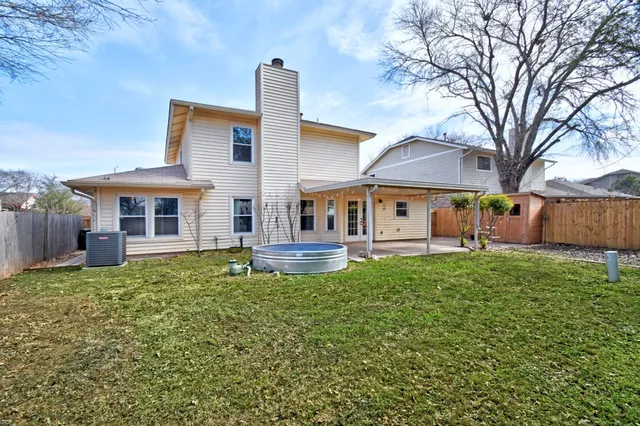 a view of a house with a backyard and a tree
