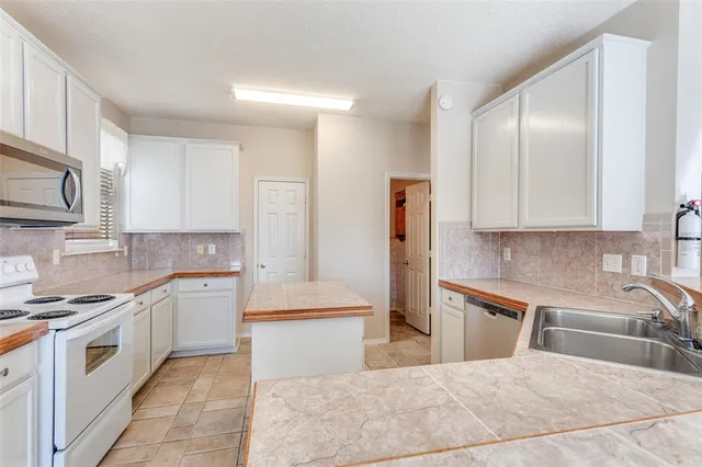 an empty room with ceiling fan and window