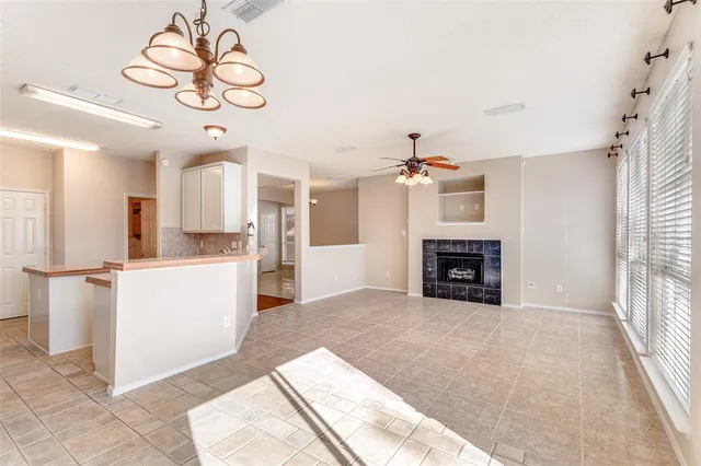 a view of an empty room with a fireplace and a window