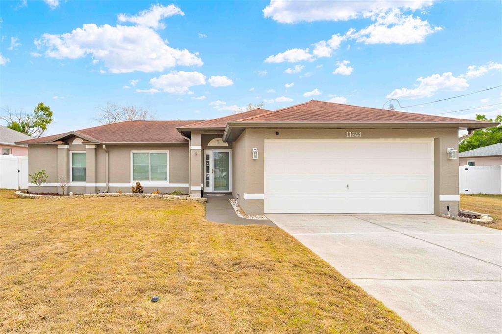 11244 Redgate Street Spring Hill, FL 34609 - Photo 1 of 50 a view of a house with a swimming pool and sitting area