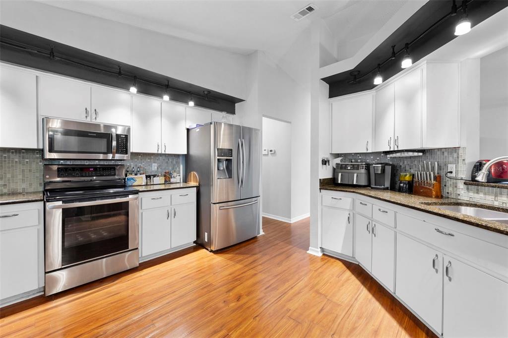 11244 Redgate Street Spring Hill, FL 34609 - Photo 14 of 50 a kitchen with stainless steel appliances a refrigerator stove microwave and sink