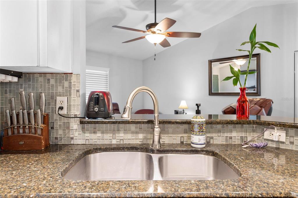 11244 Redgate Street Spring Hill, FL 34609 - Photo 17 of 50 a kitchen with a sink a counter and cabinets
