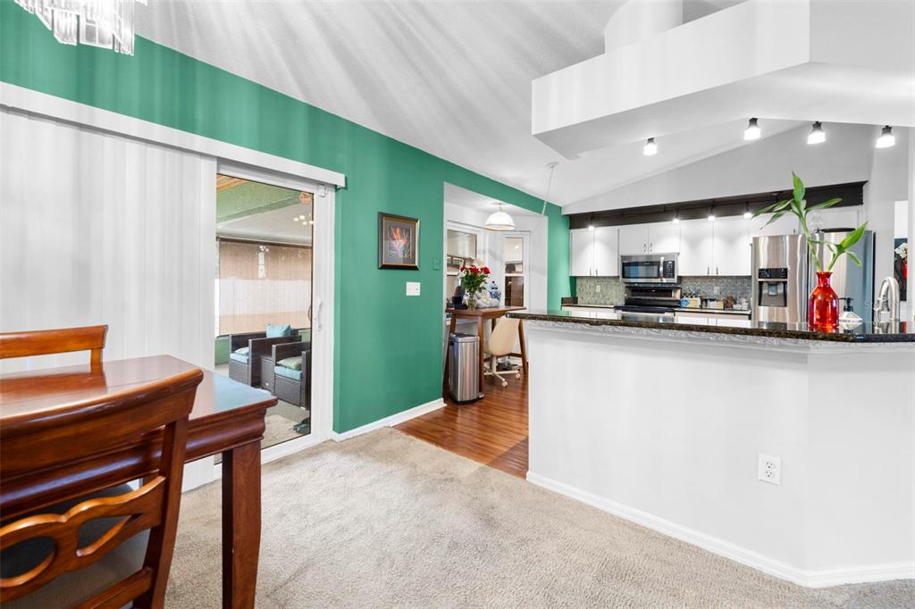 11244 Redgate Street Spring Hill, FL 34609 - Photo 20 of 50 a kitchen with stainless steel appliances kitchen island granite countertop a refrigerator and a stove top oven