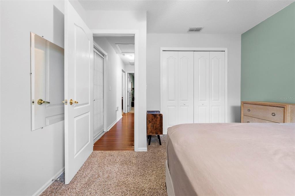11244 Redgate Street Spring Hill, FL 34609 - Photo 29 of 50 a view of a bedroom with wooden floor and hallway