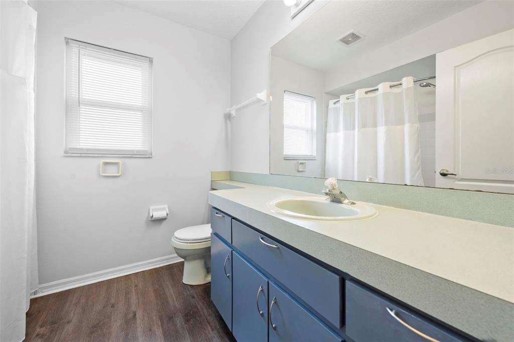 11244 Redgate Street Spring Hill, FL 34609 - Photo 32 of 50 a bathroom with a double vanity sink toilet and a mirror