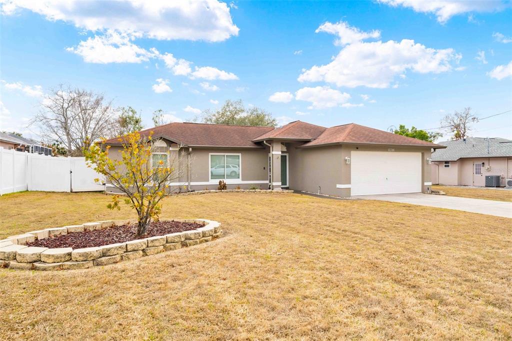 11244 Redgate Street Spring Hill, FL 34609 - Photo 33 of 50 a front view of a house with a yard