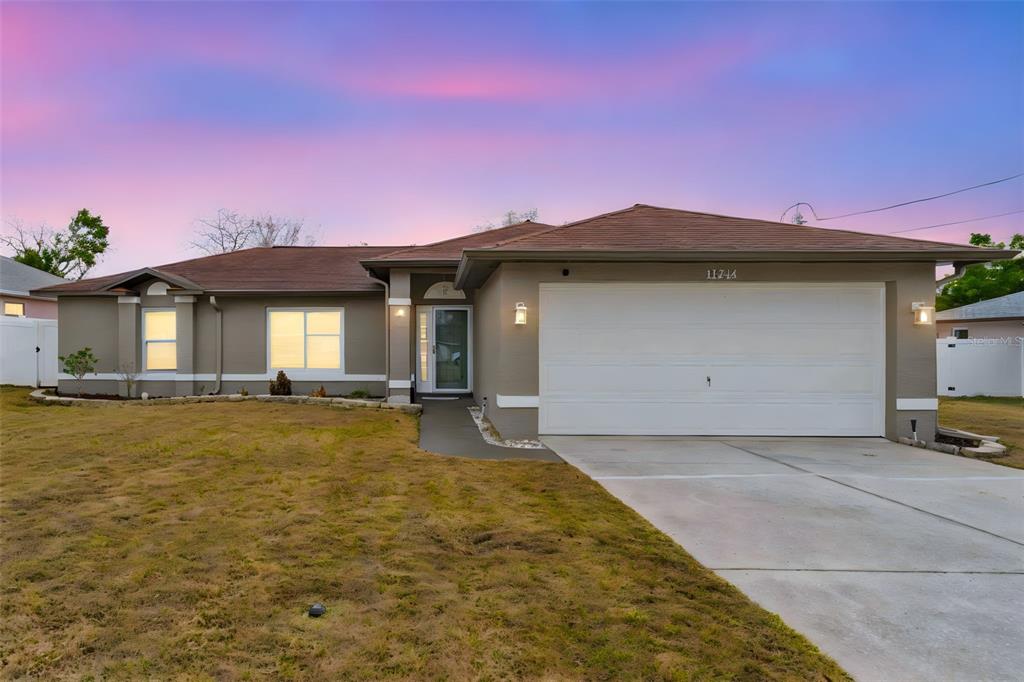 11244 Redgate Street Spring Hill, FL 34609 - Photo 36 of 50 a front view of a house with yard and garage