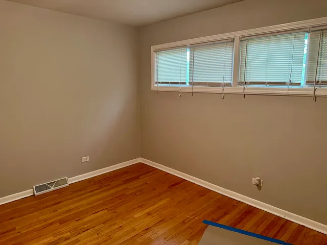 a view of a room with wooden floor and a window